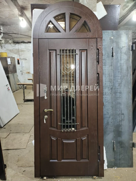 Арочная высокая дверь с кованной решёткой - фото